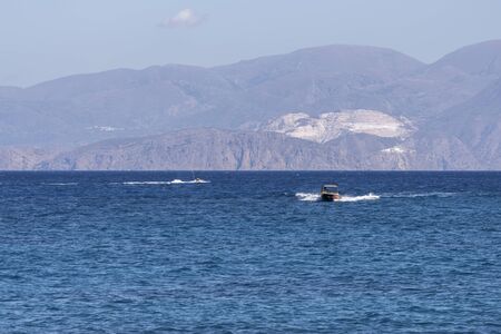 Summer sea view from coast with white yaht and mountains in background, Greeceの写真素材