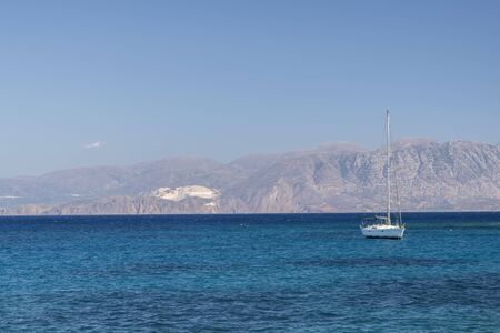 Summer sea view from coast with white yaht and mountains in background, Greeceの写真素材