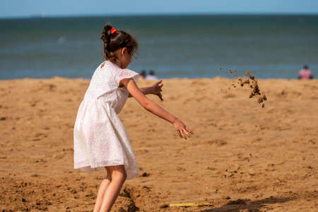 Happy child playing with sand at the beach in summer, Botany Bay, Kent, UKの写真素材
