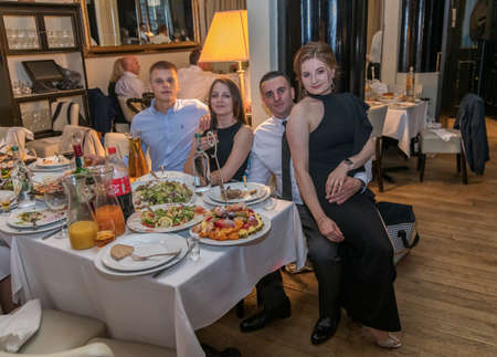 Group of friends sitting in retaurant and eating dinner, London, UKの写真素材