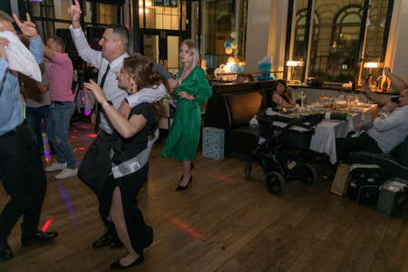 Portrait of young beautiful wedding couple dancing with restaurant in the background, London, UKの写真素材