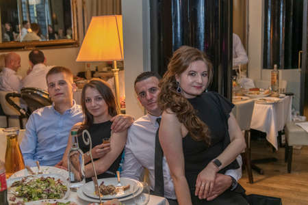 Group of friends sitting in retaurant and eating dinner, London, UKの写真素材