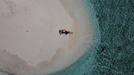 Mature lady on vacation laying on a tropical beachの写真素材