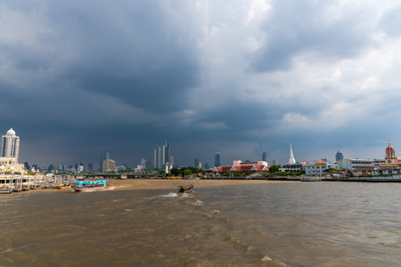 A captivating stormy river scene showcasing boats with a stunning city skyline backdropの写真素材