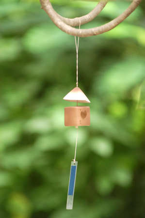 Ceramic bell hanging on treeâ€™s  branch, look like it smiling so happy 