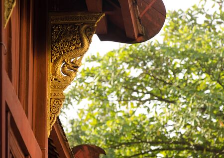 Wood sculpture of serpent decorate on the outer side of the building in Buddhist templeの写真素材