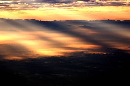 A sunlight pass through the clouds form a stream and spot of light on the groung in the basin land...