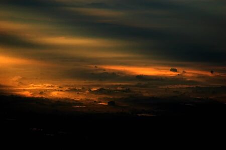 A sunlight pass through the clouds form a stream and spot of light on the groung in the basin land...