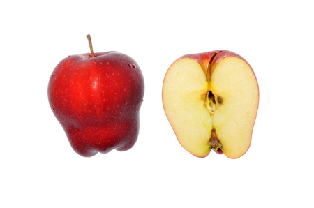 Isolate red apple, red delicious strain, a side view closeup photo of red apple and half slice isolate on bright white light background present a detail of dappled pattern and texture on apple surfaceの写真素材