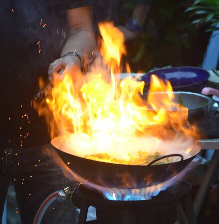 'Stir fried swamp cabbage', abstract blur image of flame on a burning pan when thai chef cooking a swamp cabbage/water spinach, cooking style, art of food cooking, thai food, food style, burning panの写真素材