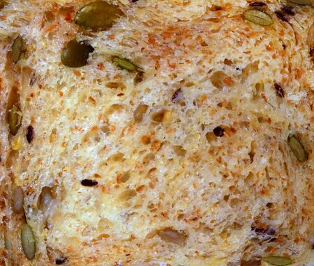 Cereal bread texture, top view closeup photo on a slice surface of cereal bread present a detail of texture on a sliced surface of cereal bread, wholewheat brownbread, healthy food, texture backgroundの写真素材