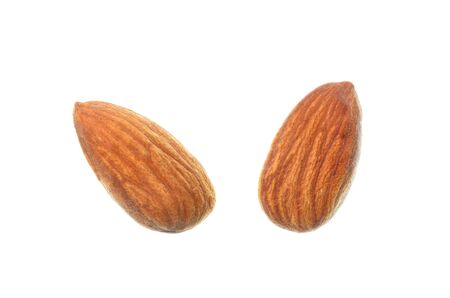 Isolated almond seed, top view closeup photo of two almond nuts isolated on a white background present a detail of texture on almond seed skin, almond nut skin texture, cereal grain healthy foodの写真素材