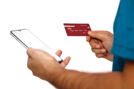 Online payment,Man's hands holding a credit card and using smart phone for online shopping.の写真素材