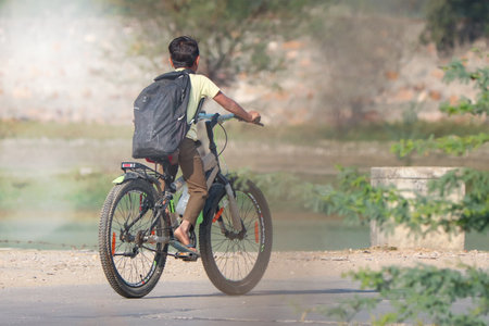Jaipur, Rajasthan, India- November 25, 2021: Young boy going to school with bicycle.のeditorial素材
