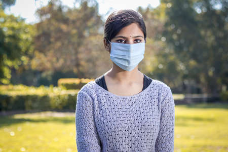 Indian teenager teen girl young woman wearing a face mask outsideの写真素材