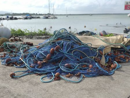 Set of blue fishing nets and ropes of different sizes on a pier in the fishing port of the Caribbean...