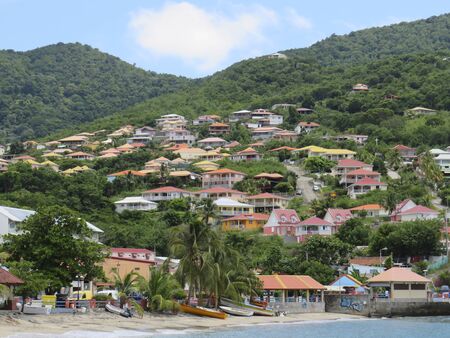 Panoramic view of the small coastal town of Anses d'arlet. Colored houses on hill with abundant vegetation. Martinique in French West Indies. Antilles Caribbean landscapeの写真素材