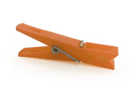 Horizontal view. Isolated orange plastic clothespin on white backgroundの写真素材