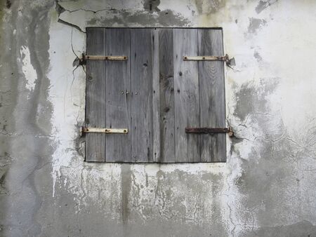 Closeup of rusty wooden window on white and black wall. Traditional architecture of the Antilles. Martinique, French West Indiesの写真素材
