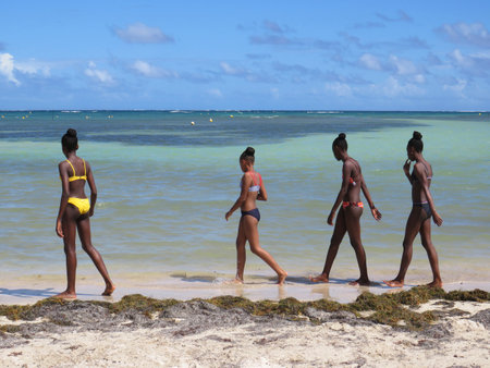 Martinique, French West Indies; December 10, 2019: Group of young Antilles on Martinique Island beach, Caribbean Sea with turquoise waterのeditorial素材