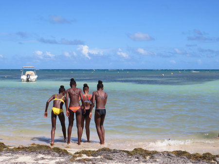 Martinique, French West Indies; December 10, 2019: Group of young Antilles on Martinique Island beach, Caribbean Sea with turquoise waterのeditorial素材