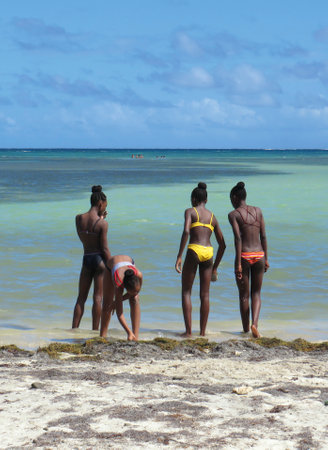 Martinique, French West Indies; December 10, 2019: Group of young Antilles on Martinique Island beach, Caribbean Sea with turquoise waterのeditorial素材