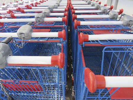 Rows of blue shopping carts collected in supermarket. Double lined shopping carts.
