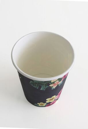 Top view. Isolated black takeaway disposable cup painted with Caribbean flowers on white background.の写真素材