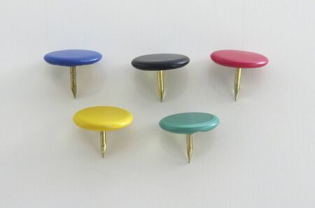 Pins of various colors on a white background. Rings of an  flag made  flat pins plastic round headの写真素材