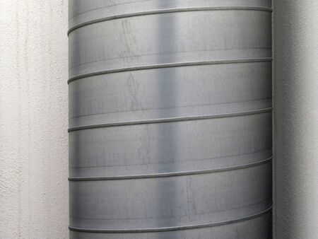 Detail of stainless steel tube ventilation system. Close up of metal tube on white wall. Industrial...