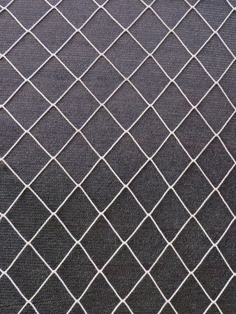 Rhombus-shaped wire mesh background on gray canvas. Rehabilitation and construction. Pattern.