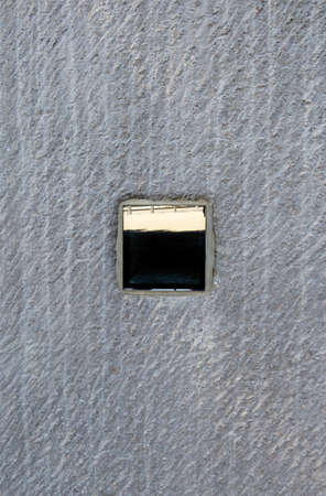 Abstract background of rough gray wall with reflective mirror box. Construction textures and...
