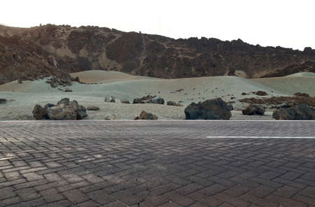 Road in volcanic landscape at sunset with Lava beds in Teide National Park, Tenerife, Canary Islands...
