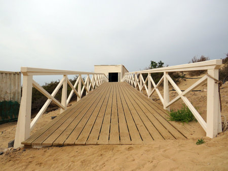 Perspective of wooden walkway to hangar in wild beach sand. Wooden footbridge walkway.の写真素材