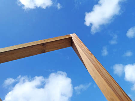 Angle view of wooden structure under tropical blue sky. Structural timber construction pillar in the French West Indies. A house in wood. Ecological architecture and handmade carpentry concept.の写真素材