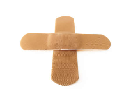 Aerial view of Cross bandage isolated on white background. Protective tape strip, wound patch close up. First aid adhesive plaster First aid and sanitary equipment concept.の写真素材