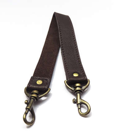 Aerial view of leather handle for bags, baskets and wallets isolated on white background. Brown strap or shoulder strap with carabiners Sustainable design. Fashion accessory and accessories concept.の写真素材