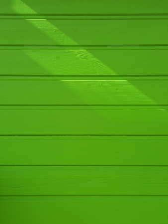 Green horizontal wooden slats wall background. Green painted wall. Intense green texture and full frame. Green wooden wall with horizontal planks. Close up of an old wooden fence panels.の写真素材