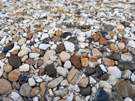 Background of sea stones of different shapes and tones. Small Naturally Polished Rocks, Pebbles...