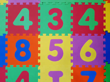 Close up of Foam colorful puzzle pieces. Children's play rubber floor background. Texture of colored...