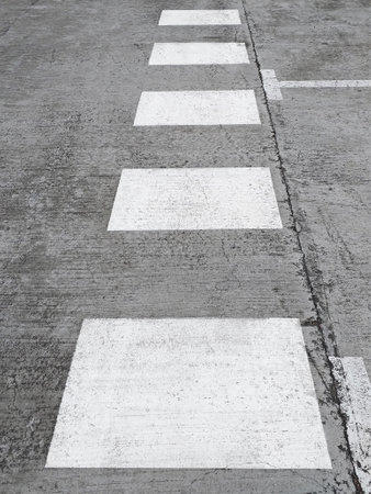 Perspective view of white crosswalk markings painted on the pavement. White discontinuous signage. traffic signals.の写真素材