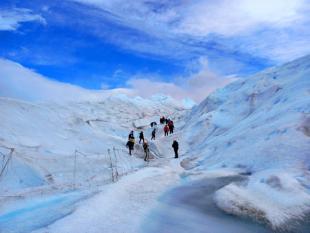 Perito Moreno, March 2022: Panoramic view of the Perito Moreno glacier with a group of climbers walking on the ice. Trekking, adventure and extreme nature.のeditorial素材