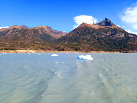 Andes mountains with cloudy waters and waves with ice blocks under blue sky of Patagonia Argentina. Nature and extreme landscapes.の写真素材