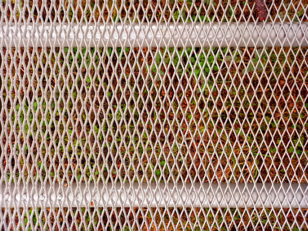 Close up of metal sheet on colorful background. Steel grid texture. Full frame metal mesh....