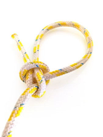 Perspective view of cape with isolated sailor knot. Knot tied in rope on white background. Close up of Loop knot. Navigation and Mooring concept.の素材