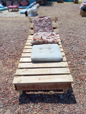 Wooden lounger and cushions on the Sinai Peninsula. Front view of empty sun lounger. Chill out and relaxation.の写真素材