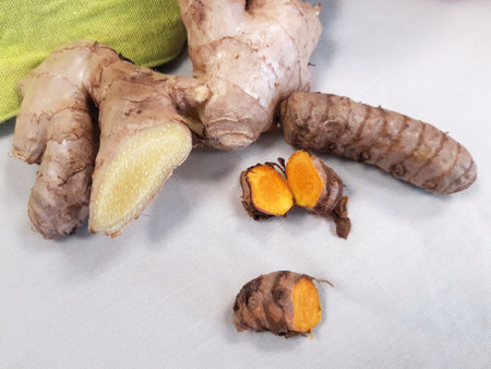 Aerial view of fresh split natural ginger and turmeric pieces. Ginger root and spice closeup. Ready...