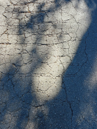 Abstract cracked concrete floor background. Rough gray surface texture. Broken asphalt full frame.の写真素材