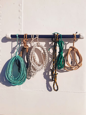 Ropes of different sizes and shapes tied on the deck of a ship. Front view of marine ropes for ships. Close up of anchor ropes with sailor knots. Nautical and maritime navigation elementsの写真素材
