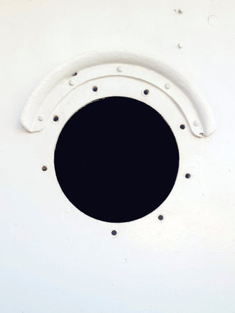 Hole in the warship. Brass porthole, ferry window frame. Background of an old ship metal round window. Close up of porthole of merchant ship.の写真素材